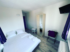 Chambre de l'Hôtel Abaca&nbsp;: grand lit confortable, armoire, télévision