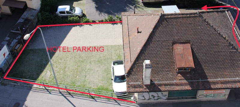 Vue aérienne du parking de l'hôtel Abaca, délimité en rouge derrière l'épicerie de Gilamont
